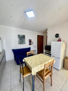 eine Küche mit Tisch und Stühlen und einem Kühlschrank in der Unterkunft Apartment 2 steps from Ile-Rousse Beach in LʼÎle-Rousse + 3 Fotos
