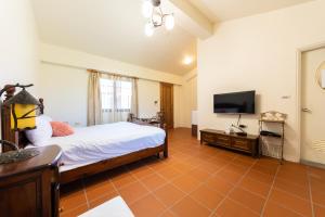 a bedroom with a bed and a flat screen tv at 宜蘭閑居民宿 in Suao