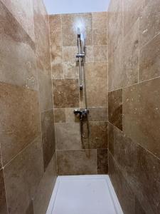 a bathroom with a shower with brown tiles at Studio cosy en plein cœur du centre-ville in Avignon