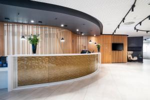 a lobby with a reception desk with flowers on it at NH Graz City in Graz