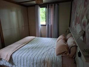 una piccola camera da letto con un letto e una finestra di Chalet au bois tranquille a Saint-André-de-Double Altre 18 foto