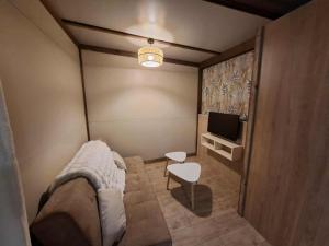 una piccola stanza con un letto e una televisione di Chalet au bois tranquille a Saint-André-de-Double