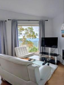 Una sala de estar con un sofá blanco y una ventana grande. en Armand Heights, en Ganges