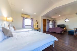 a bedroom with a large white bed and a living room at 宜蘭閑居民宿 in Suao +68 photos