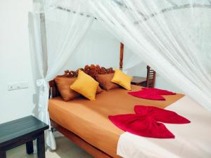 a bedroom with a bed with red bows on it at Brave resort Mirissa in Mirissa