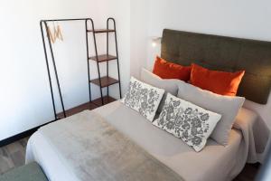 a bedroom with a bed with pillows and a shelf at La Carrera 7 - Baños Árabes - Parking sujeto a disponibilidad in Jaén
