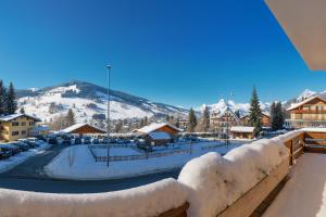 a resort with snow covered buildings and a mountain at White Lodges - Megève center on ski slopes in Megève
