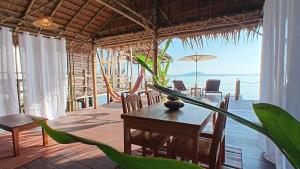 a dining room with a table and a view of the ocean at Tropical Sea Front House in Ko Po