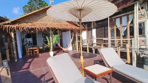 a patio with chairs and an umbrella on a house at Tropical Sea Front House in Ko Po +15 photos