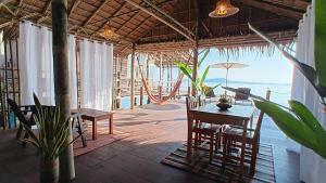a dining room with a table and chairs and the ocean at Tropical Sea Front House in Ko Po