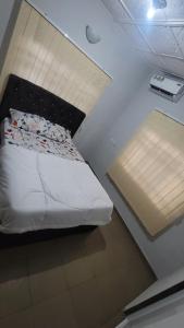 Cama pequeña en habitación con techo en Hometune, en Lagos