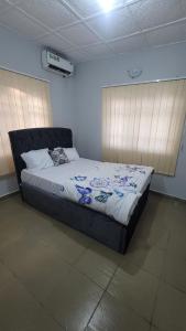 Un dormitorio con una cama en una habitación con ventanas. en Hometune, en Lagos