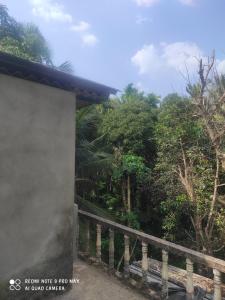 a side view of a house with a fence and trees at House in Mirjān