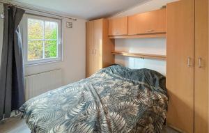 a bedroom with a bed and cabinets and a window at Awesome Stacaravan In Goedereede With Wifi in Goedereede