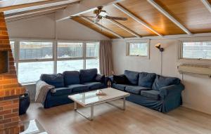 a living room with two blue couches and a table at 3 Bedroom Cozy Home In Korsør in Tjæreby
