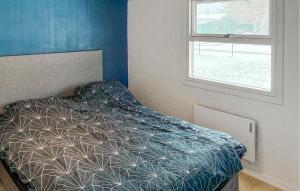 a bedroom with a bed with a comforter and a window at 3 Bedroom Cozy Home In Korsør in Tjæreby +10 photos