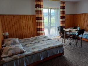 Un dormitorio con una cama y una mesa y sillas. en Pokoje Gościnne Murowanica, en Murzasichle