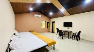 a bedroom with a bed and a table with chairs at Evergreen bliss farm in Karjat