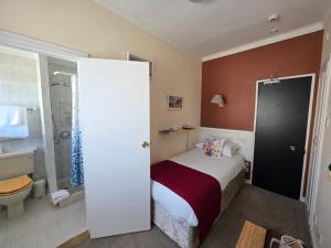 a small bedroom with a bed and a shower at Marina Metro Hotel in Saint Helier Jersey +50 photos