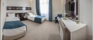 a hotel room with two beds and a desk at Theater Hotel Belgrade in Belgrade
