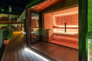 a large glass door on a deck at night at Hotel Opinione Dimora Storica & Private Spa in San Lorenzo in Banale