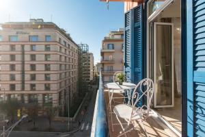 a balcony with a table and chairs and buildings at MainAvenue White Tower in Thessaloniki