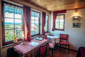 a dining room with a table and chairs and windows at Varsádi Birtok Piano in Somlóvásárhely