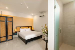 En eller flere senge i et værelse på Vooc Signature Hotel Hoi An