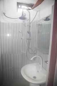 ein weißes Badezimmer mit Dusche und Waschbecken in der Unterkunft Wood Aura Ella in Ella