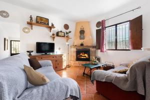 Caminito Del Rey Valley House في Valle de Abdalagís: غرفة معيشة مع كنبتين ومدفأة