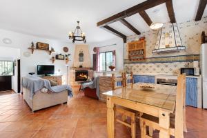 Caminito Del Rey Valley House في Valle de Abdalagís: مطبخ وغرفة معيشة مع طاولة خشبية