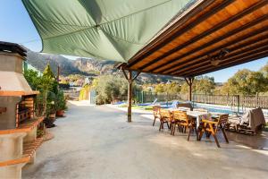 Caminito Del Rey Valley House في Valle de Abdalagís: فناء مع طاولة وكراسي ومظلة