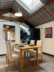 a dining room with a wooden table and chairs at Balmoral Lodge, King Size Apartment by The Hive WA1 in Warrington