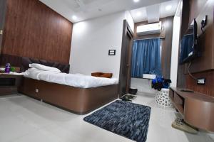 Una televisión o centro de entretenimiento en Asha Banquet And Hotels