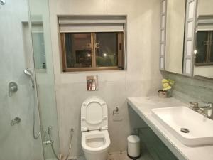 a bathroom with a toilet and a sink and a shower at Beach villa South Goa in Arossim-Cansaulim
