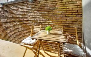 a wooden table and two chairs in front of a brick wall at 2 Bedroom Nice Apartment In Castellón De La Plana in Castellón de la Plana