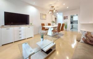 a living room with a television and a table with chairs at 2 Bedroom Nice Apartment In Castellón De La Plana in Castellón de la Plana