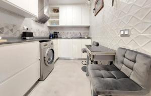 a kitchen with a washing machine and a table and a chair at 2 Bedroom Nice Apartment In Castellón De La Plana in Castellón de la Plana