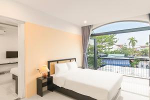 En eller flere senge i et værelse på Vooc Signature Hotel Hoi An + 56 billeder