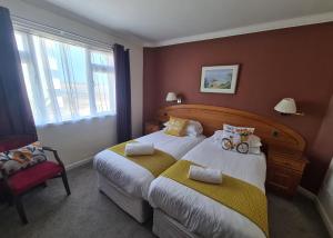 a hotel room with two beds and a window at Marina Metro Hotel in Saint Helier Jersey