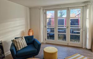 sala de estar con silla azul y puerta corredera de cristal en 2 Bedroom Awesome Apartment In Skagen, en Skagen