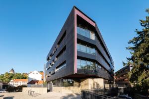 a tall black building with a lot of windows at NH Graz City in Graz