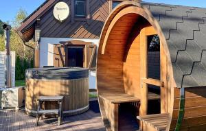 Un cenador de madera con un banco al lado de una casa. en Nice Home In Prokowo With Sauna, en Prokowo