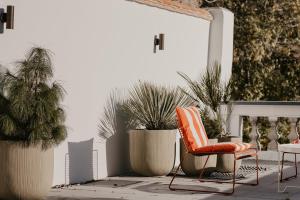 an orange chair sitting on a patio with potted plants at Isidore in Bruges