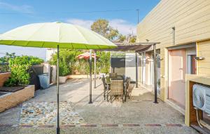 a patio with an umbrella and a table and chairs at Villa La Playa in Saint-Raphaël