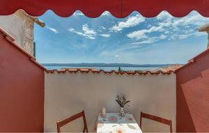 Nice Apartment In Bol With Wifi في بول: طاولة وكراسي على شرفة منزل