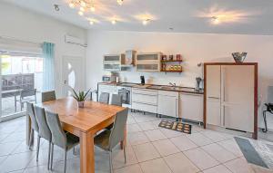 a kitchen with a wooden table and a refrigerator at Villa La Playa in Saint-Raphaël