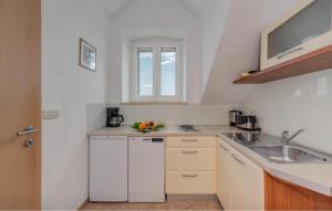 Nice Apartment In Bol With Wifi في بول: مطبخ بخزائن بيضاء ومغسلة ونافذة