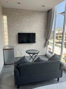 a living room with a couch and a tv on a brick wall at 萊家莉民宿 in Xiaoliuqiu