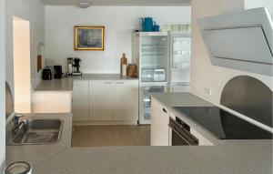 a kitchen with white cabinets and a stainless steel refrigerator at 7 Bedroom Stunning Home In Samsø in Kolby Kås